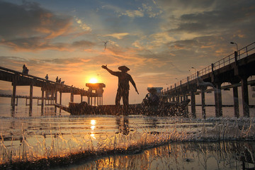 Water splash of Silhouette fishermen using nets to catch fish during sunrise time at Bang Pra...