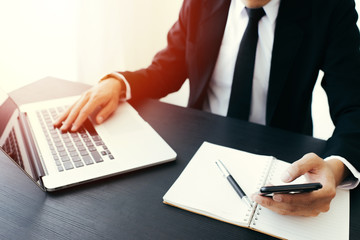 Side view shot of a man's hands using smart phone in interior, rear view of business man hands busy using cell phone at office desk,Business man using laptop computer,Business man working at office 