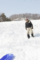Fototapeta na wymiar A child at play sledding