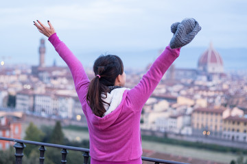 Fototapeta na wymiar Asian lady feeling excited when reaching the peak viewing great view at Florence city, Italy