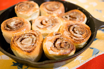 Homemade cinnamon rolls in iron pan.