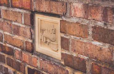 Old red brick wall texture grunge background with a locomotive inset