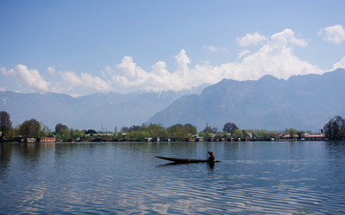 Fototapeta na wymiar Person in canoe travelling across river in India