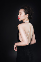 Fototapeta premium Asian woman with fashion makeup in luxury black dress while confetti falling on her.