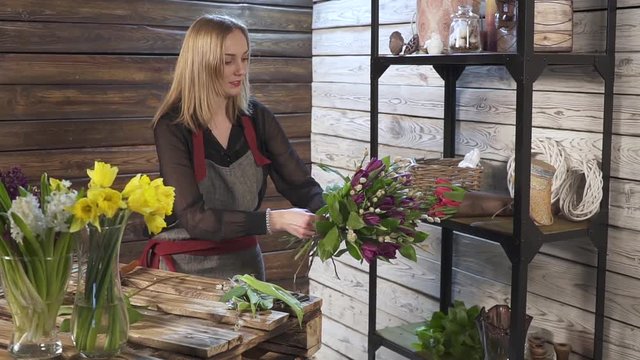 Florist in own flower shop, preparing bouquets