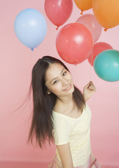 Young woman holding balloons