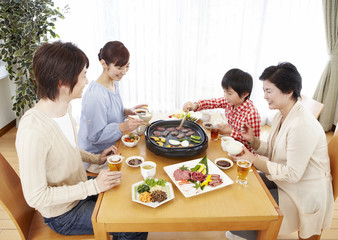 Three-generation family eating Japanese barbeque