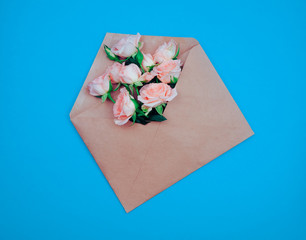 the Kraft envelope on a wood background with roses, concept, holiday, gift, copy space for text