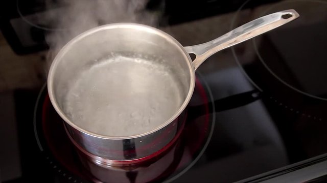 A Pot of Boiling Water on the Stove (rapid boil with steam)