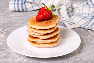 Homemade pancakes with strawberries on white plate