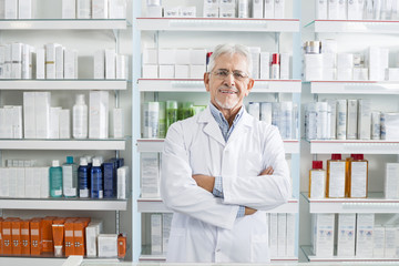 Confident Chemist Standing Arms Crossed In Pharmacy