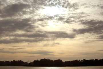 Fototapeta premium light clouds over the forest and the river