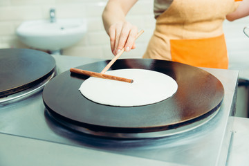 Fototapeta na wymiar Cooking pancakes. Cooks hands cook pancakes