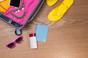 Travel and vacations concept. Open traveler's bag with clothing, accessories, credit card, tickets and passport.
