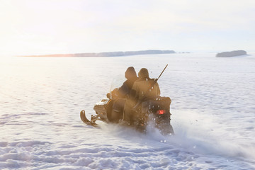 hunters by snowmobile in snowy field
