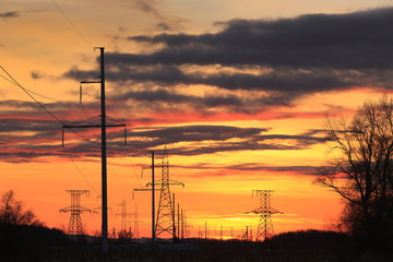transmission line on a background of bright red sunset