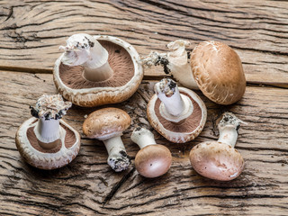 Champignon mushrooms on the wooden table.