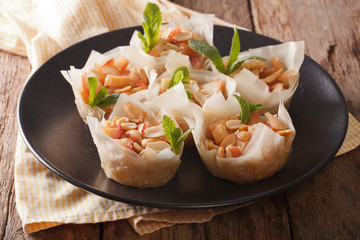 Baked filo pastry with apples and peanuts close-up on a plate. horizontal