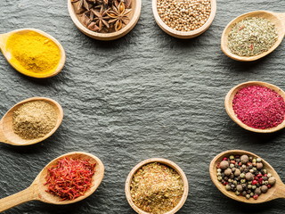 Assortment of colorful spices in the wooden spoons.