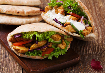 Pita salad with roasted chicken and vegetables, served with a delicious sauce.