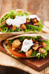 Pita salad with roasted chicken and vegetables, served with a delicious sauce.