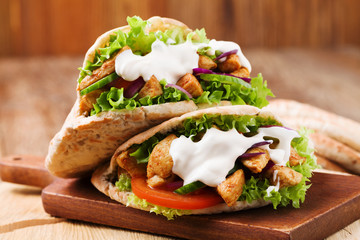 Pita salad with roasted chicken and vegetables, served with a delicious sauce.