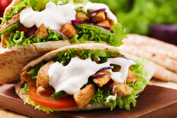 Pita salad with roasted chicken and vegetables, served with a delicious sauce.