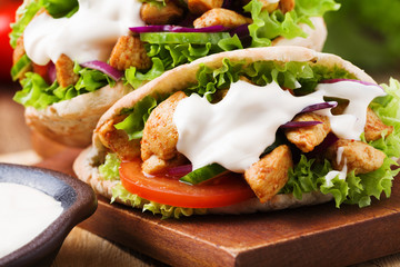 Pita salad with roasted chicken and vegetables, served with a delicious sauce.
