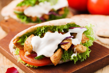 Pita salad with roasted chicken and vegetables, served with a delicious sauce.