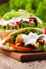 Pita salad with roasted chicken and vegetables, served with a delicious sauce.