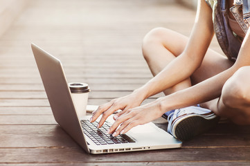 Naklejka premium Young woman using laptop computer outdoors