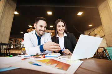 Coffee break. Business partners make short breake watching videos while doing paper work at table.