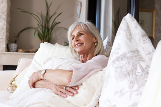 happy older woman sitting on couch relaxed