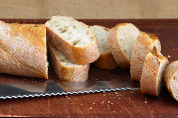 Bread in slices on a dark brown board