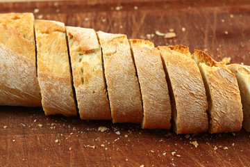 Bread in slices on a dark brown board