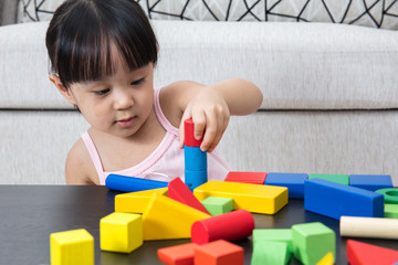 Asian Chinese little girl playing building blocks at home