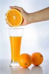  Glass of fresh orange juice and woman hand holding orange fruit