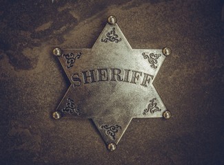 Sheriff badge on natural stone background. Macro shot.