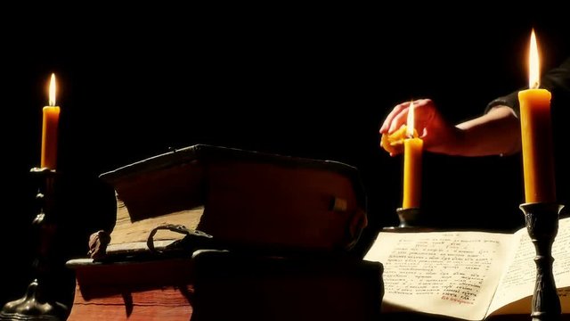 Ancient books on the table by candlelight
