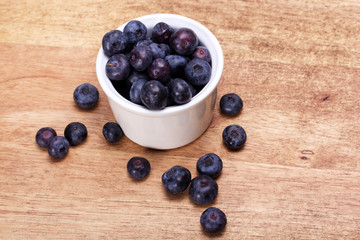 Pot of blueberries on a rustic background