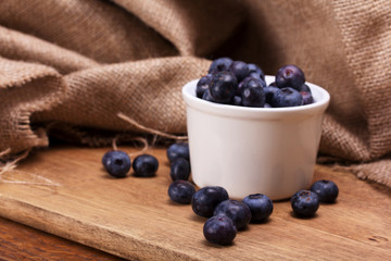 Pot of blueberries on a rustic background