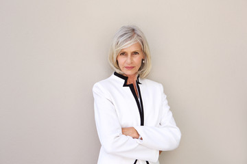 beautiful older woman staring and standing with arms crossed