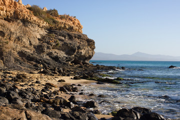 Black rocks of Costa Calma beach. Blue coastline. Playa Barca, Fuerteventura, Canary islands, Spain. Istmo de la pared view