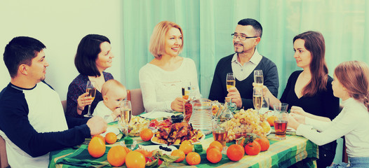 Big positive family sitting at holiday table