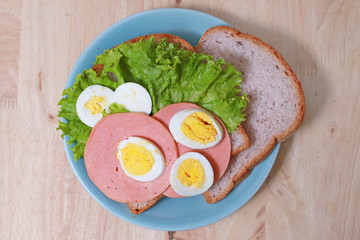 simple breakfast with Sandwich and egg on the wood table