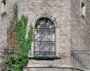 Fototapeta na wymiar Ancient prison window with lattice and wooden shutter