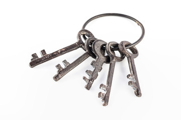 Five antique rural keys at metal ring isolated at white background.