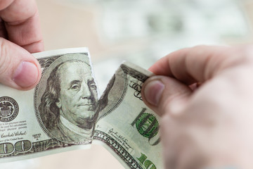 Torn dollar. Two hands tearing dollar bill