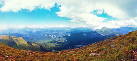 Mountain view, hiking through the mountains, panorama. Summer hiking trip. Sky, clouds and nature in the highlands, hiking trails. Traveling in the mountains.