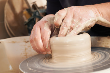 Close Up Of Potter Moulding Clay On Wheel